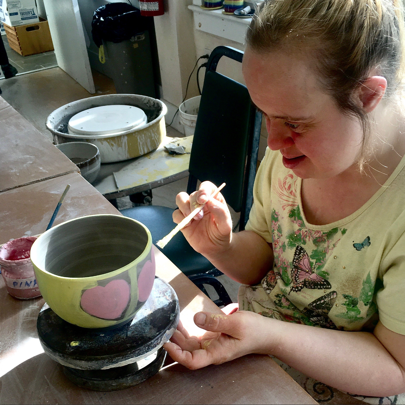 A woman painting a ceramic bowl