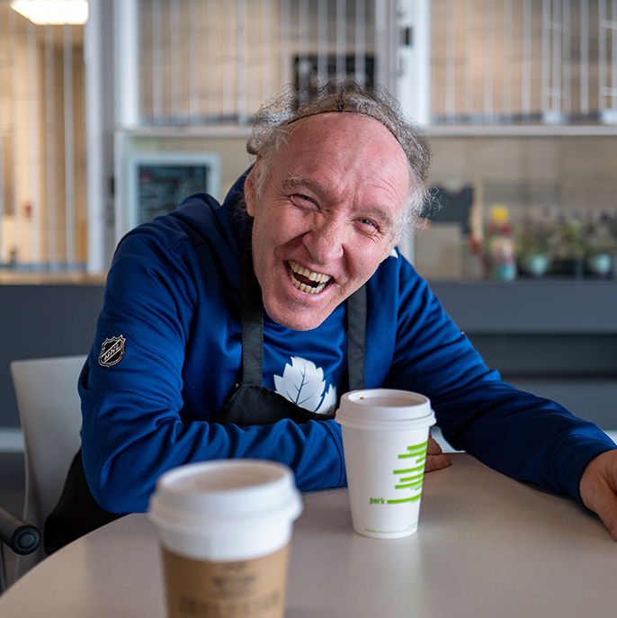 Hamilton - A coremember smiling with a coffee