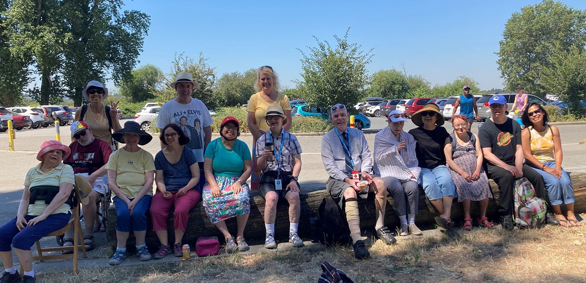 large group photo of members from L'Arche Greater Vancouver outside in the summer